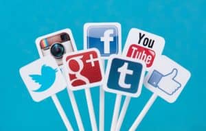 Social media icons on sticks with a blue background.