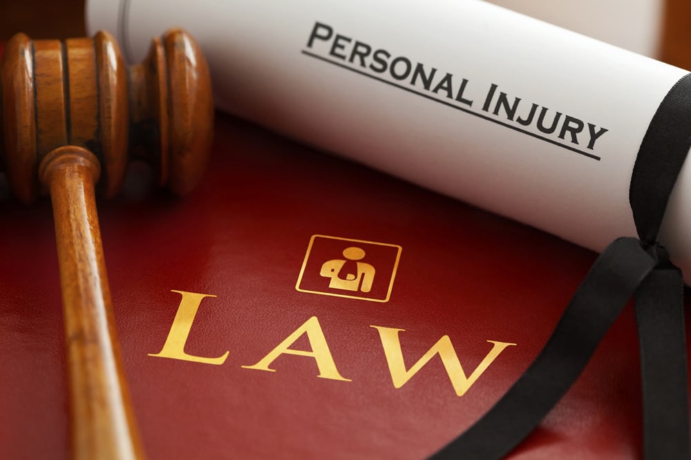 A scroll with the words 'personal injury' ontop of a red book and a gavel