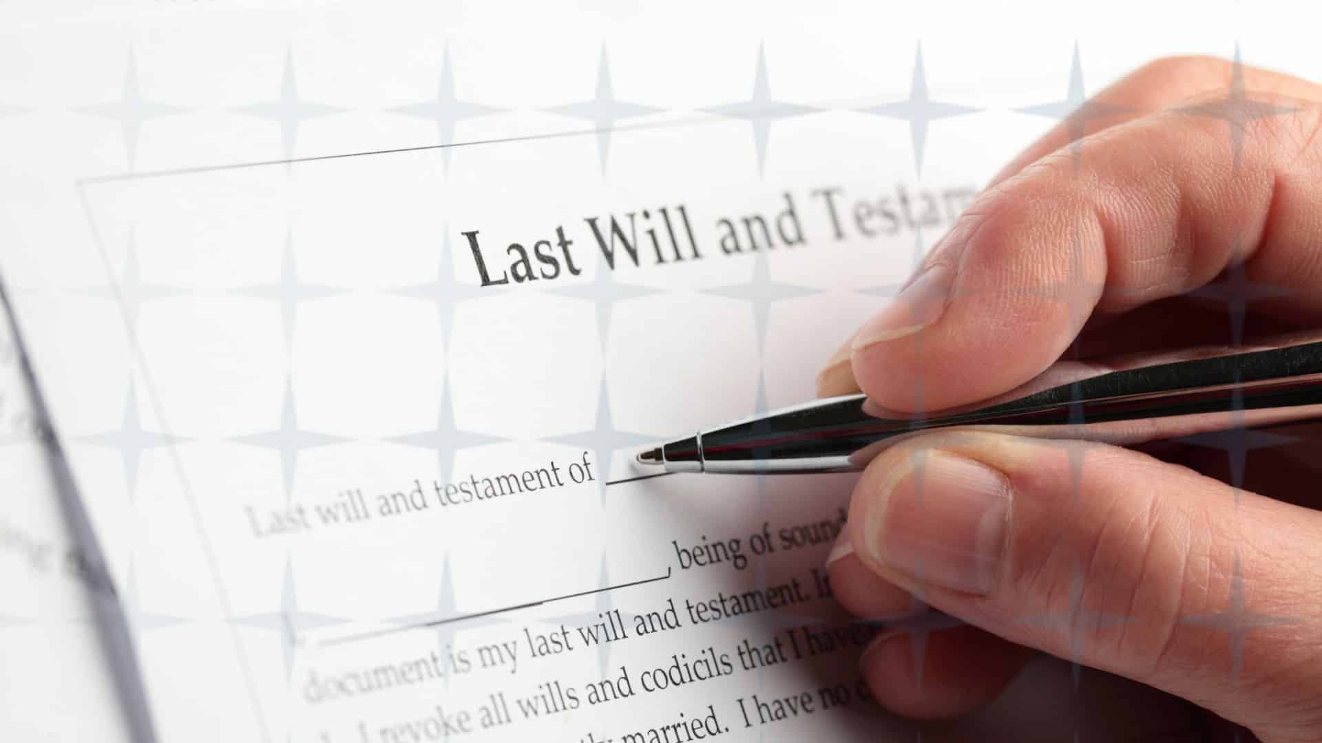 Hamd holding a pen to sign a Will.