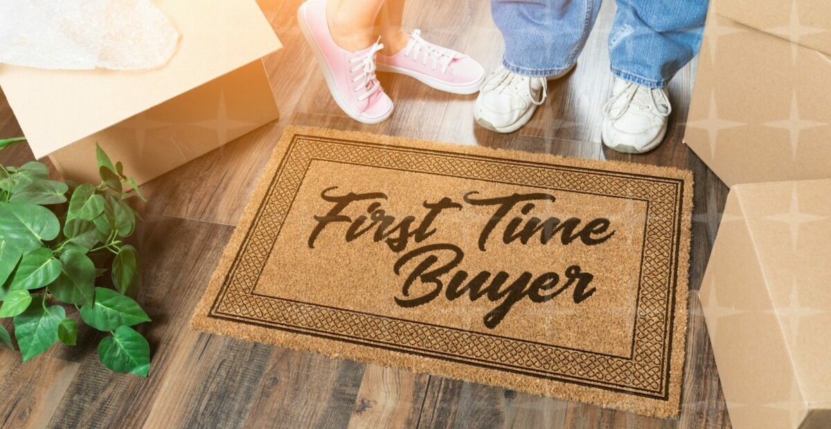 Two pairs of feet next to a doormat reading 'First Time Buyers'.